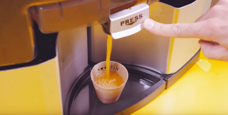 Bebe zumo de naranja en un vaso bioplástico impreso en 3d con cáscara reciclada